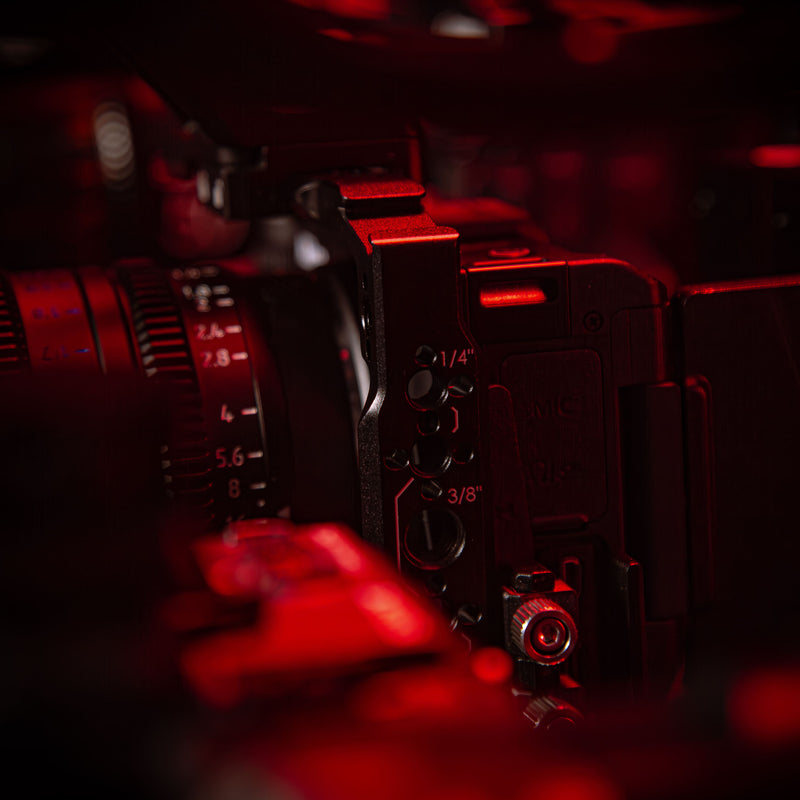 SHAPE Nikon ZR camera cage close-up showing 1/4-20 and 3/8-16 threaded mounting points in red cinematic lighting in close up